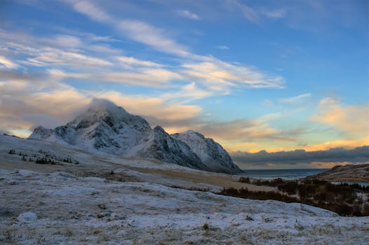 Breathtaking winter scene in Nordland, Norway with snow-covered mountains at sunset.