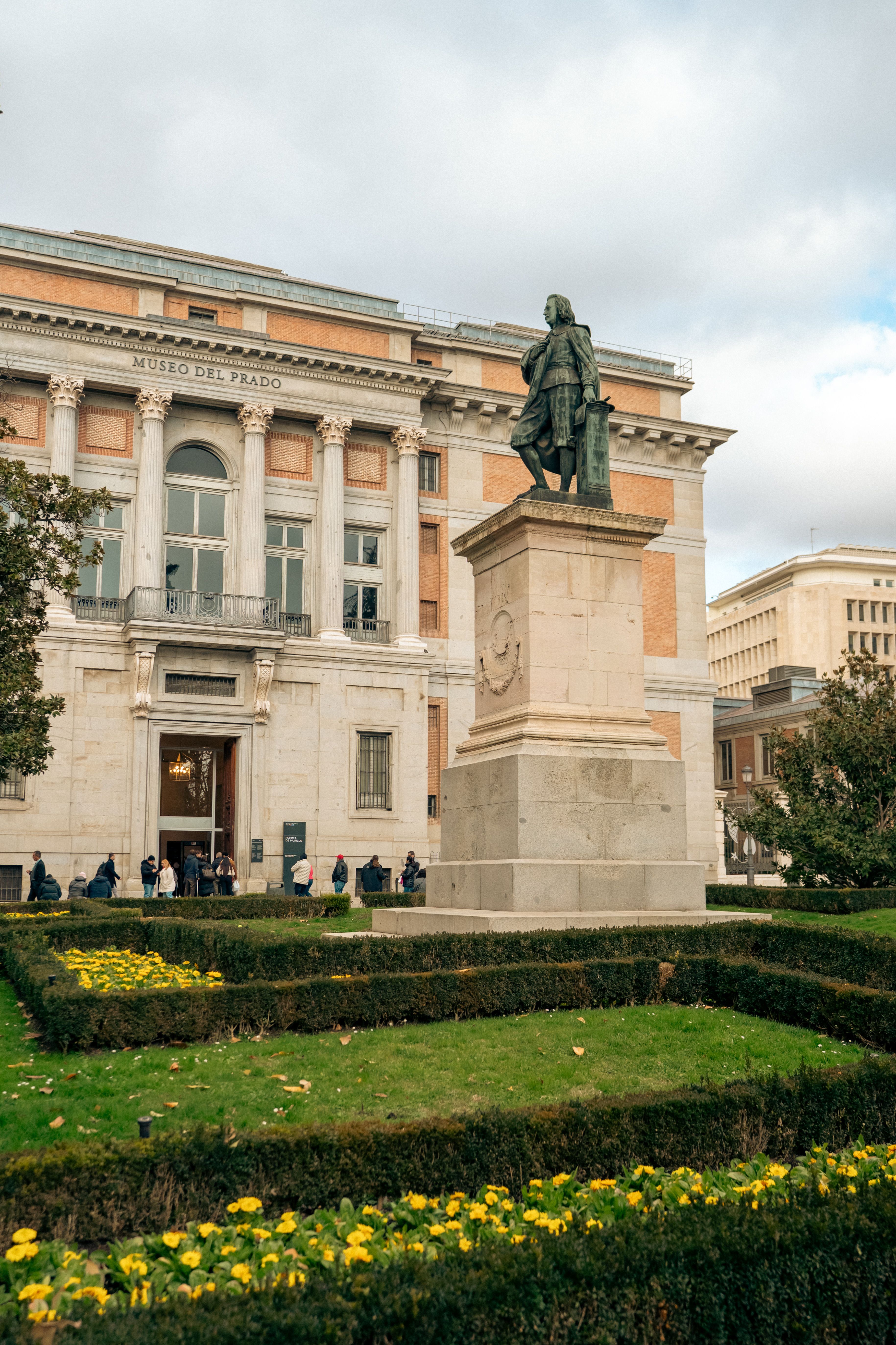 Statue and Museo del Prado facade in Madrid, ideal for cultural and travel content.