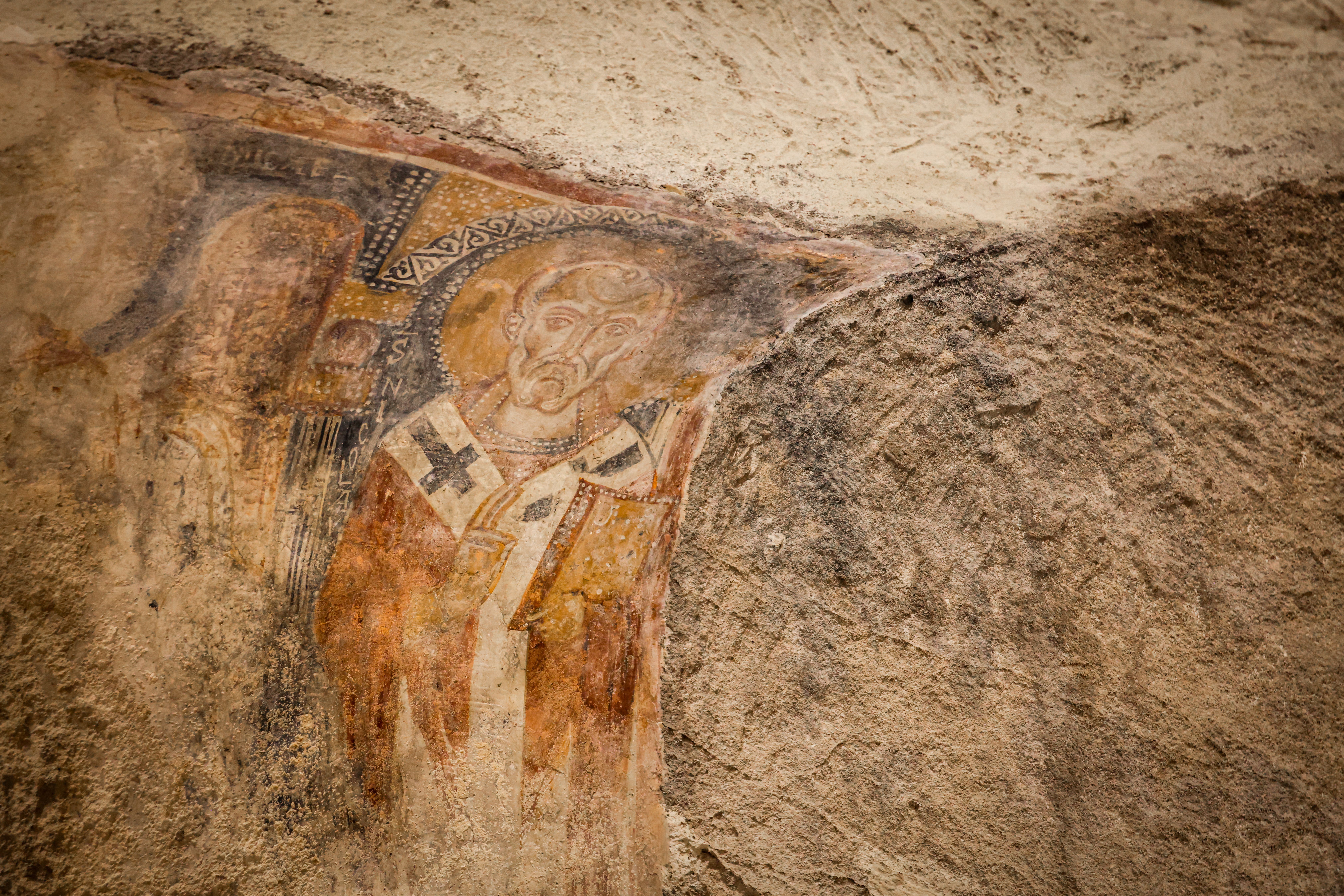 Detail of a historic fresco painting on a church wall, depicting religious art.