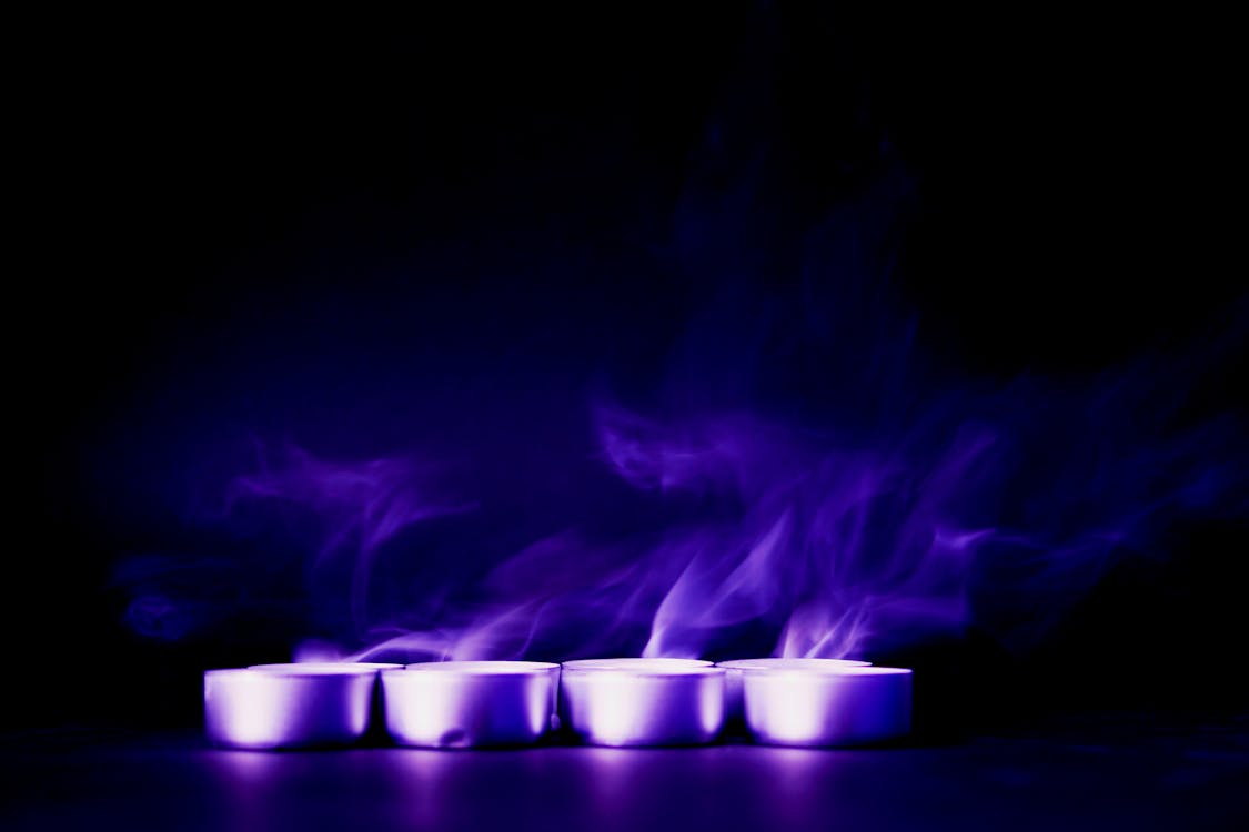 Four Tealight Candles With Purple Background