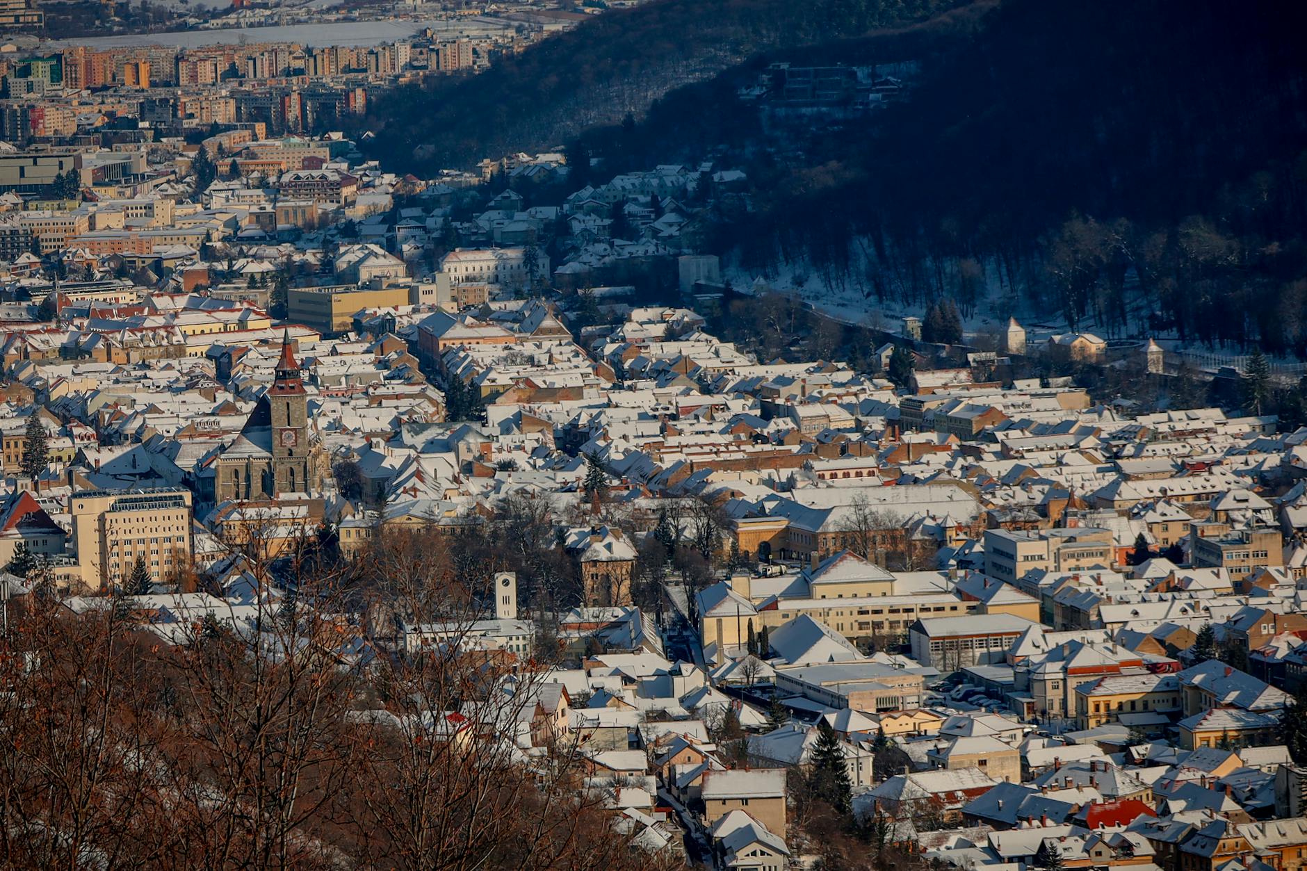Brasov Romania Winter Cityscape With Gothic Black Church, Christmas Tree, Medieval Saxon Walls, And Snow-covered Mountains
