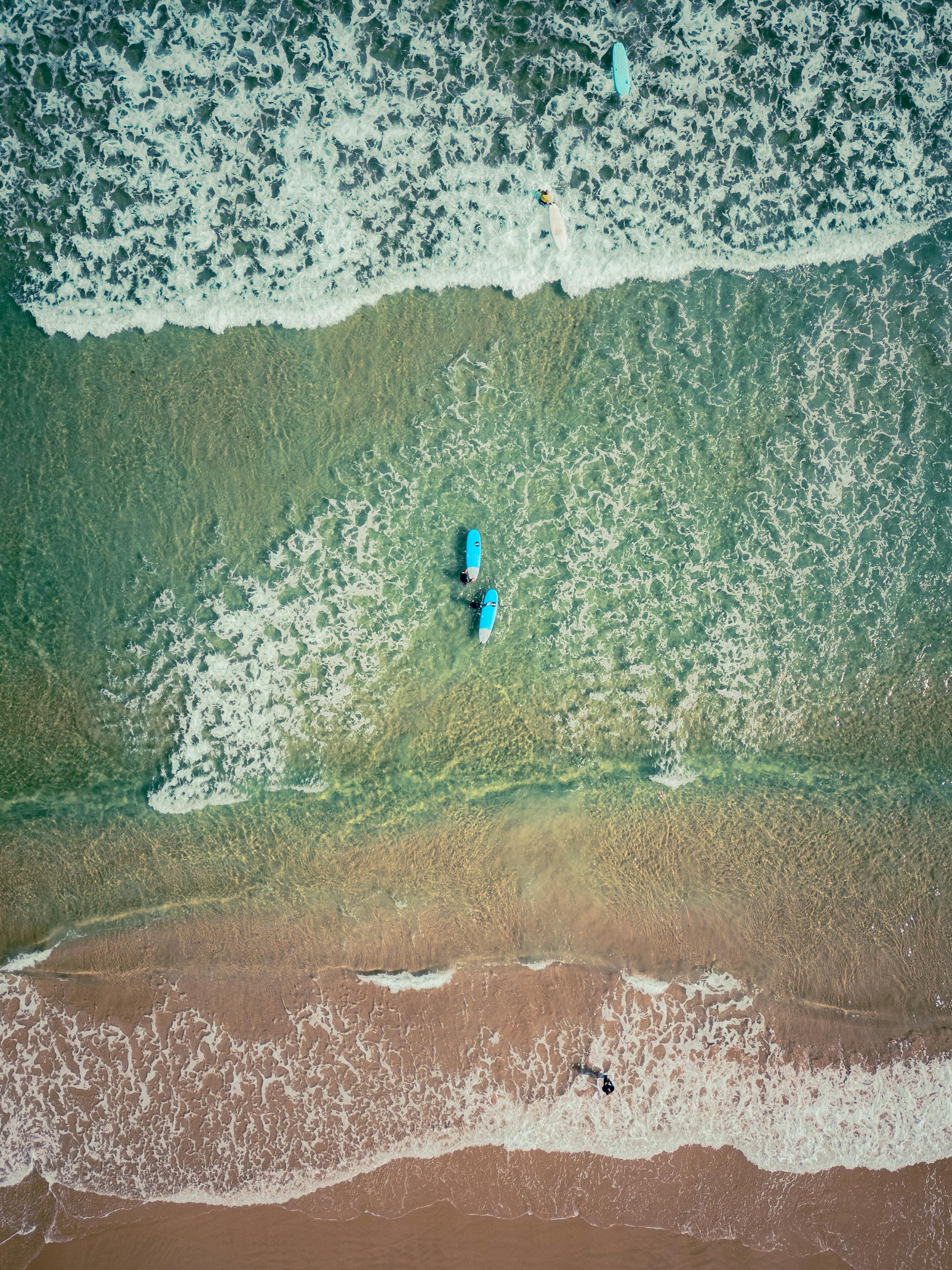 免費 空拍照片顯示，衝浪者在葡萄牙佩尼切海灘享受夏日海浪。 圖庫相片