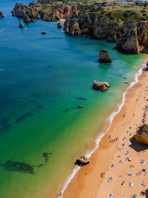 Free Aerial shot of Algarve's breathtaking coastline with turquoise waters and golden sands. Stock Photo