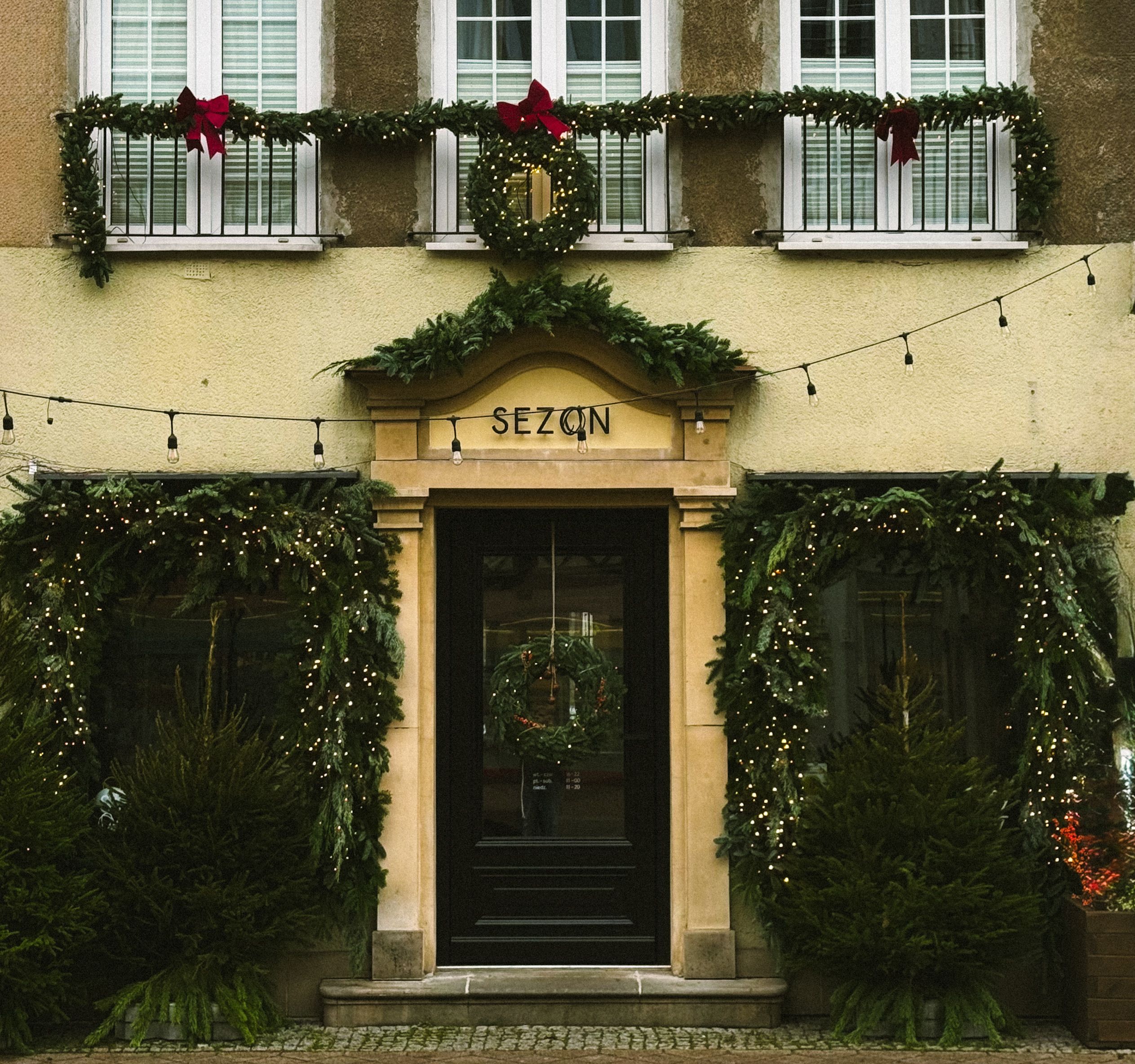 Charming building facade adorned with festive Christmas decorations and greenery.