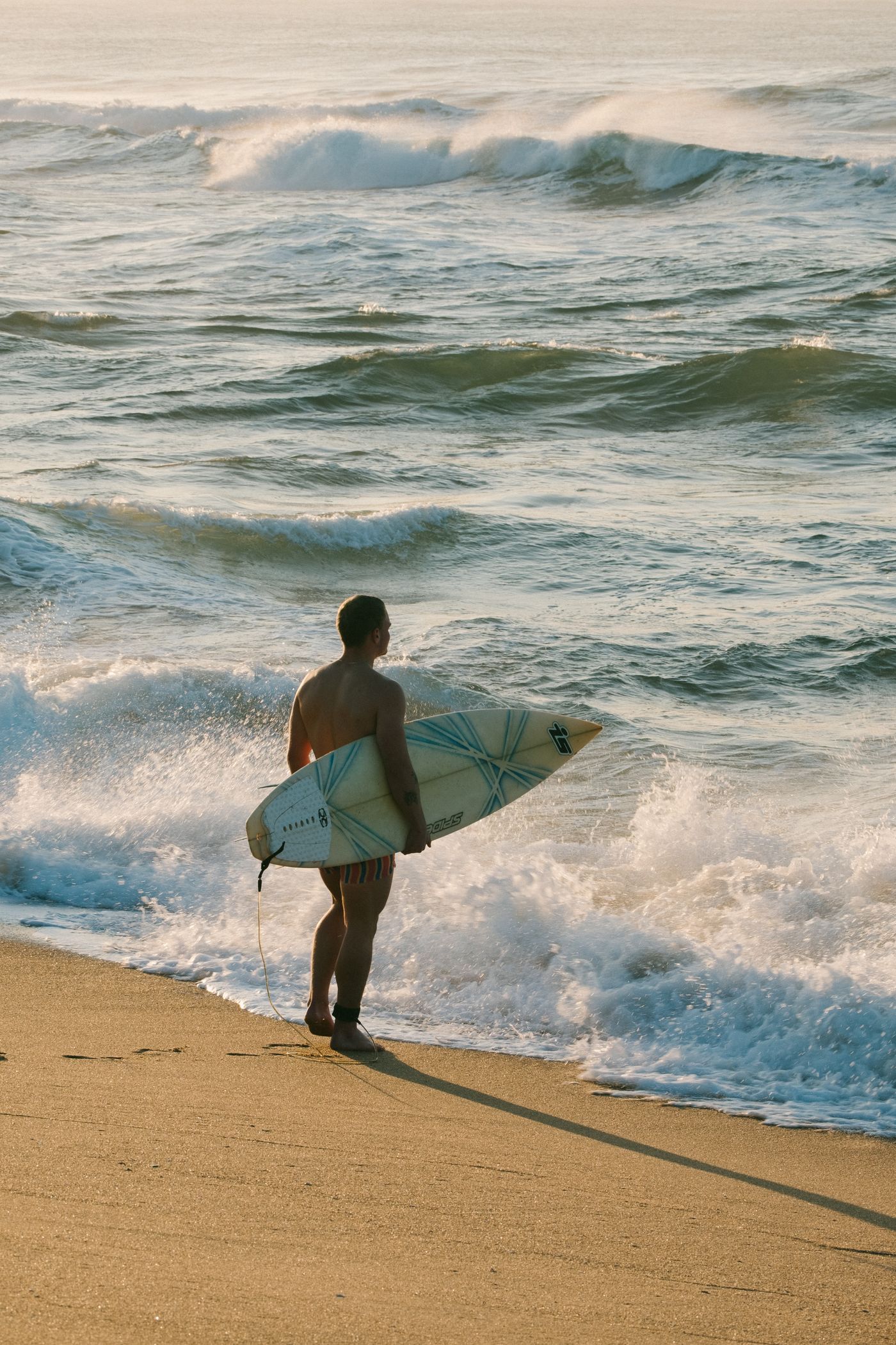 Surfer carrying a surfboard on a Durban beach