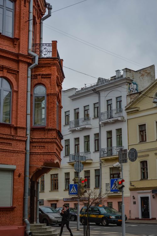 Free Street view featuring historic architecture, a pedestrian, and cars at an intersection. Stock Photo