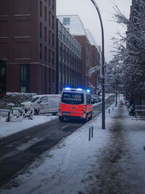 Free Firetruck on a snowy street in Hamburg during winter, showcasing urban emergency response. Stock Photo