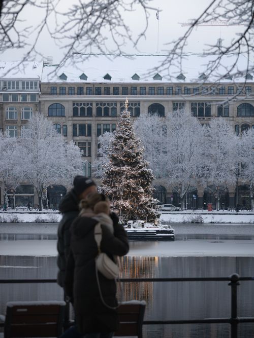 Free A beautiful winter scene in Hamburg featuring a decorated Christmas tree by the river. Stock Photo