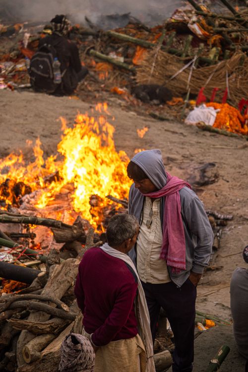 Free A solemn Hindu cremation ceremony near a riverbank highlighting spiritual traditions and cultural heritage. Stock Photo