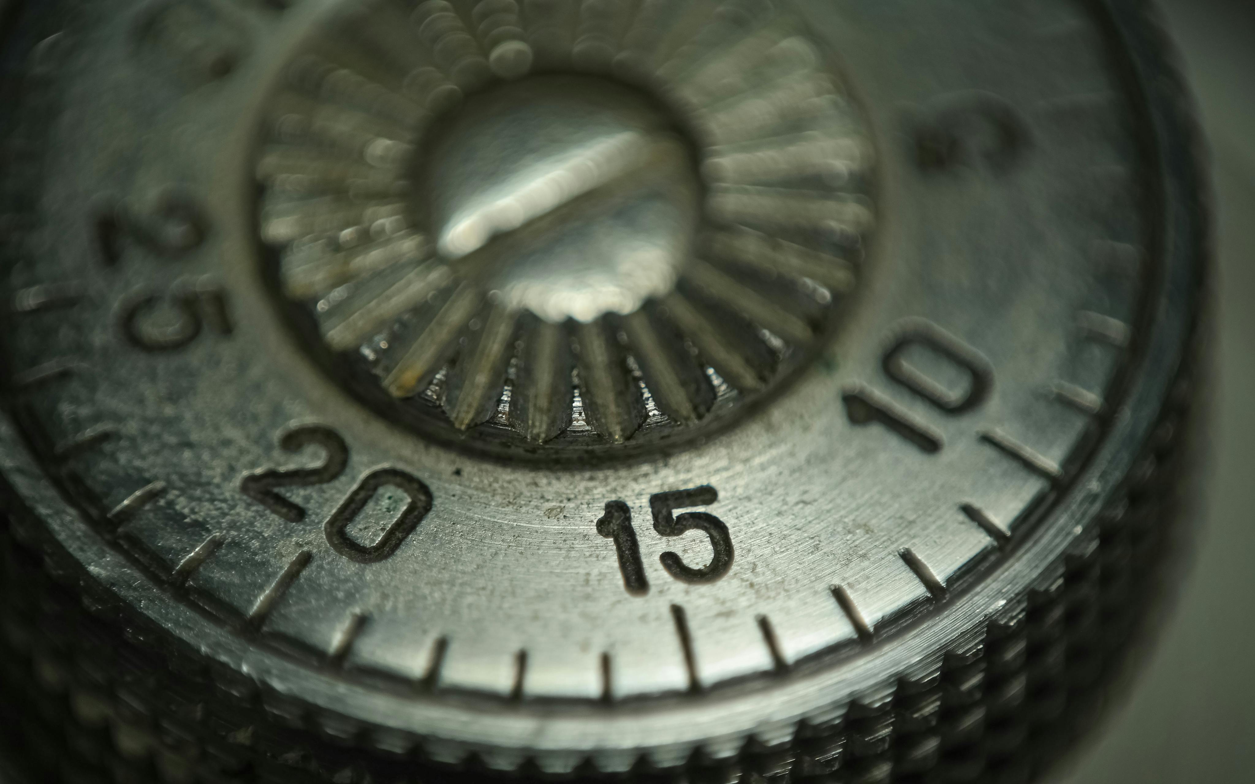 Detailed macro shot of a metallic combination lock dial showing numbers and texture.