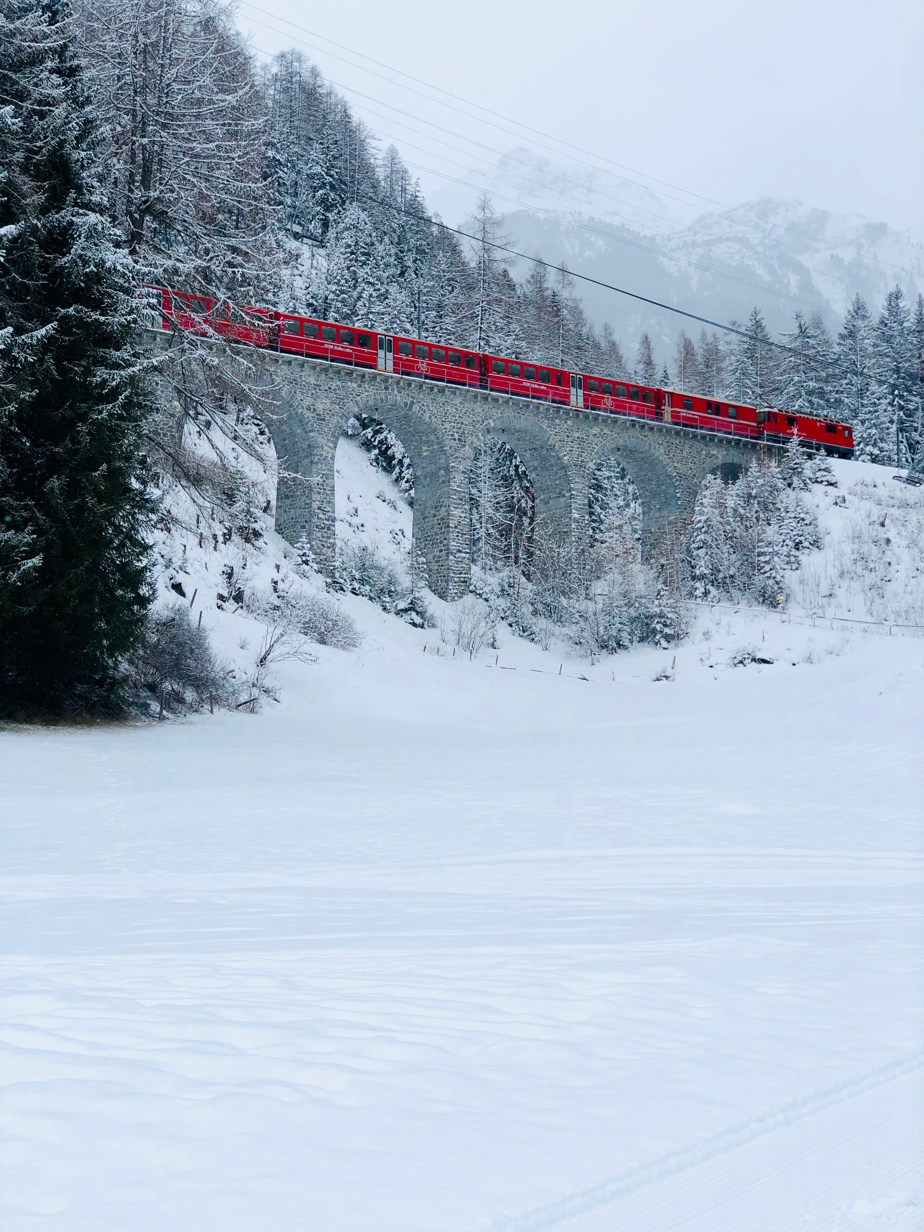 Red Train on Winter Viaduct in Swiss Alps · Free Stock Photo