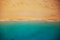 航拍镜头令人惊叹，捕捉了沙滩与碧绿海水交汇的美景，非常适合激发旅行灵感