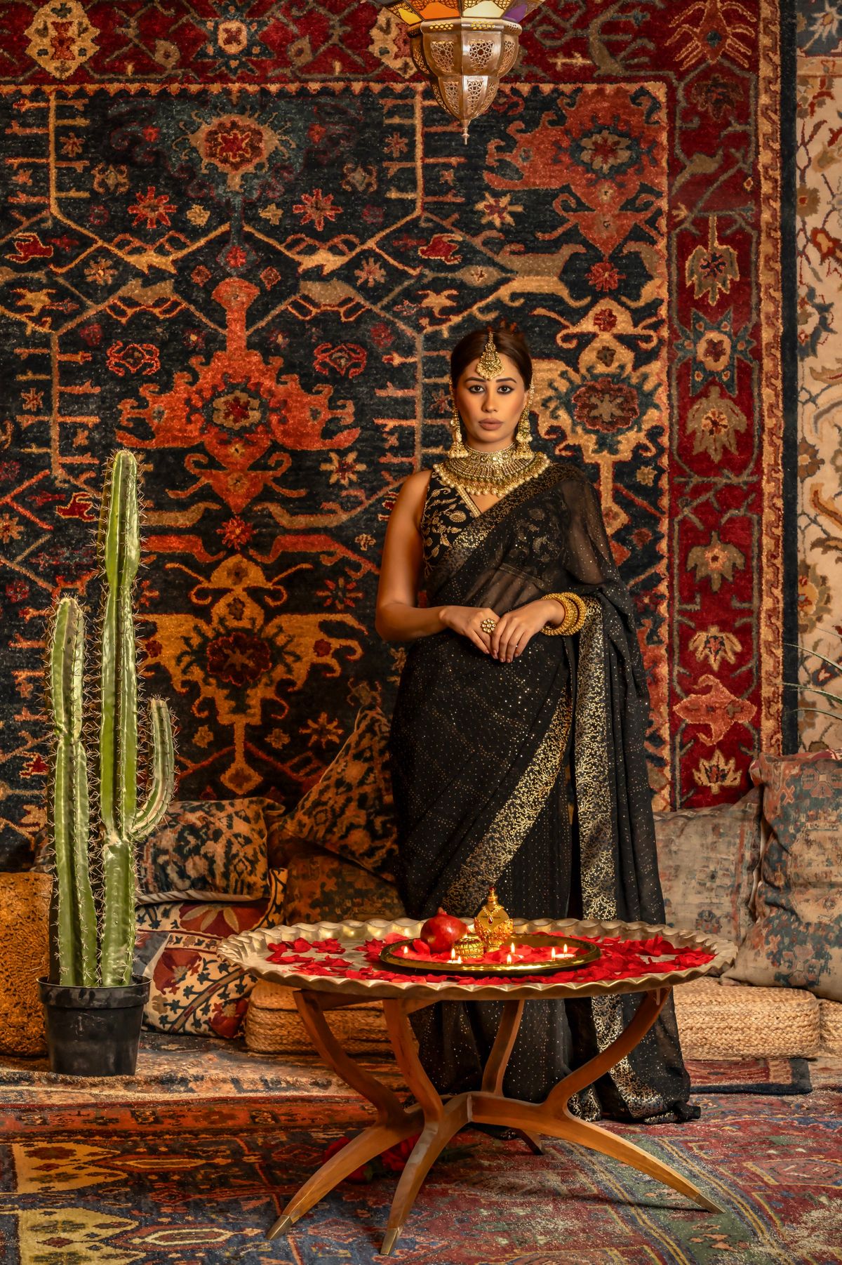 Fashion model wearing an elegant black and gold saree with gold jewellery