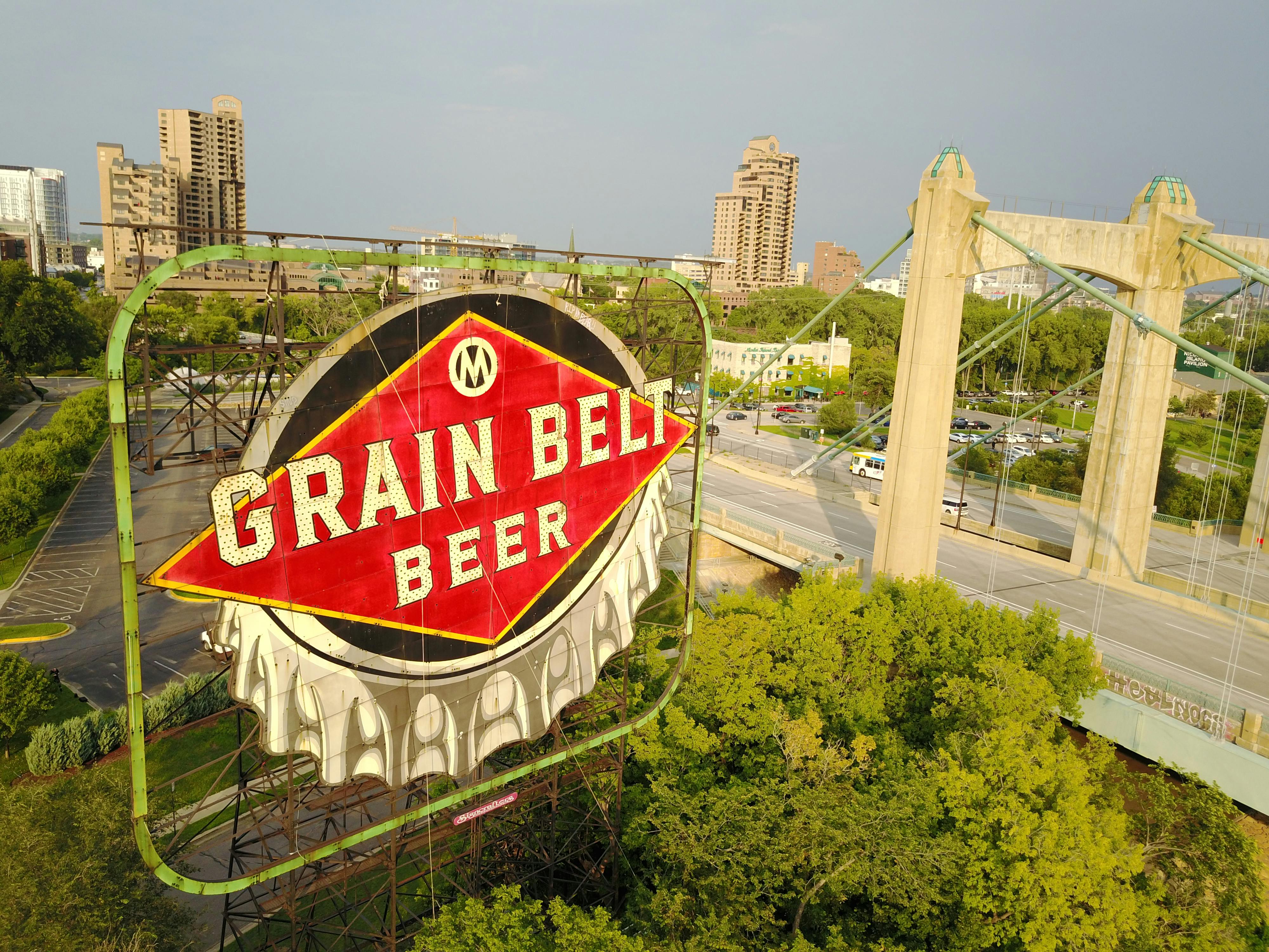 Iconic Grain Belt Beer sign and Minneapolis bridge captured from above during daytime.