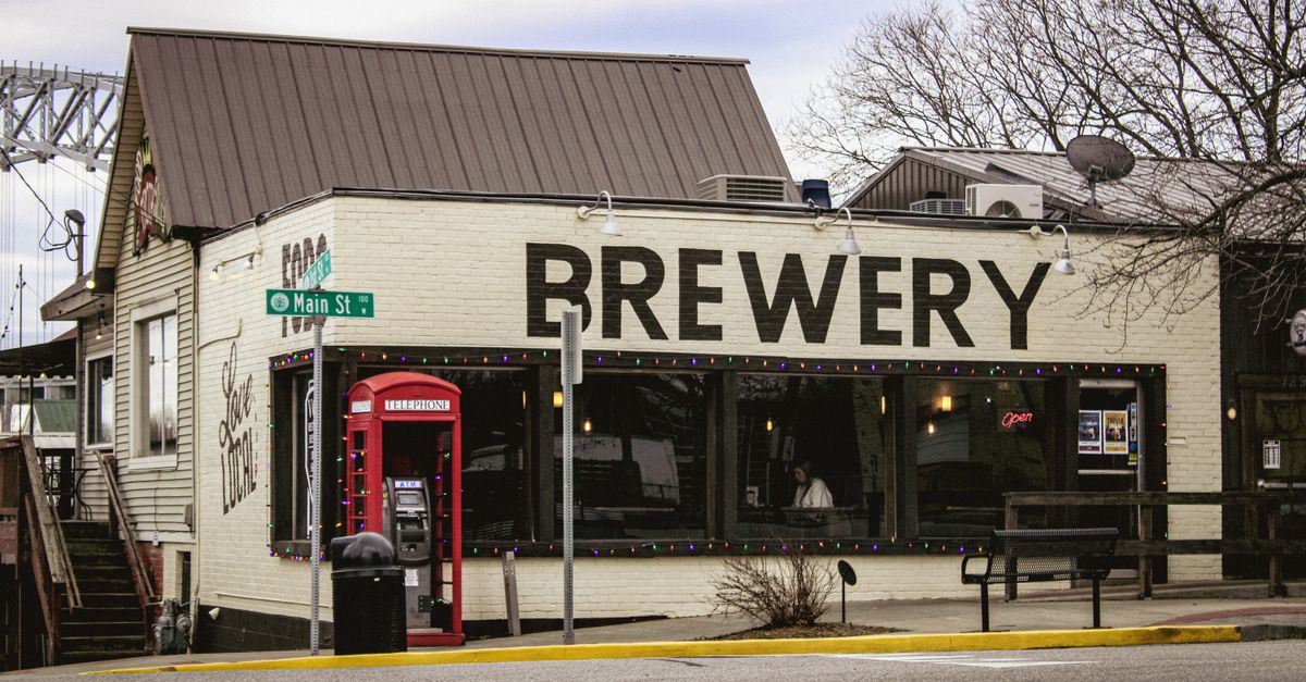 Charming historic brewery on Main Street with classic red phone booth and festive lights.