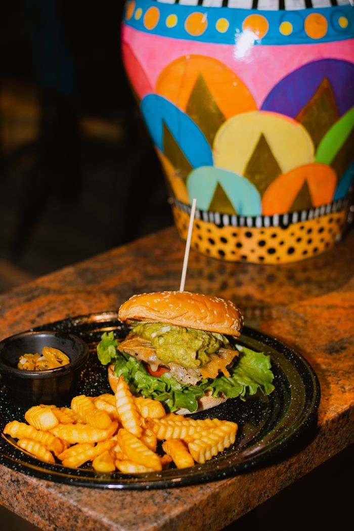 The FUEL Smash burger with crinkle fries on a rustic table