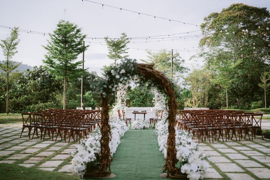 Garden ceremony arch with rows of chairs and soft lights