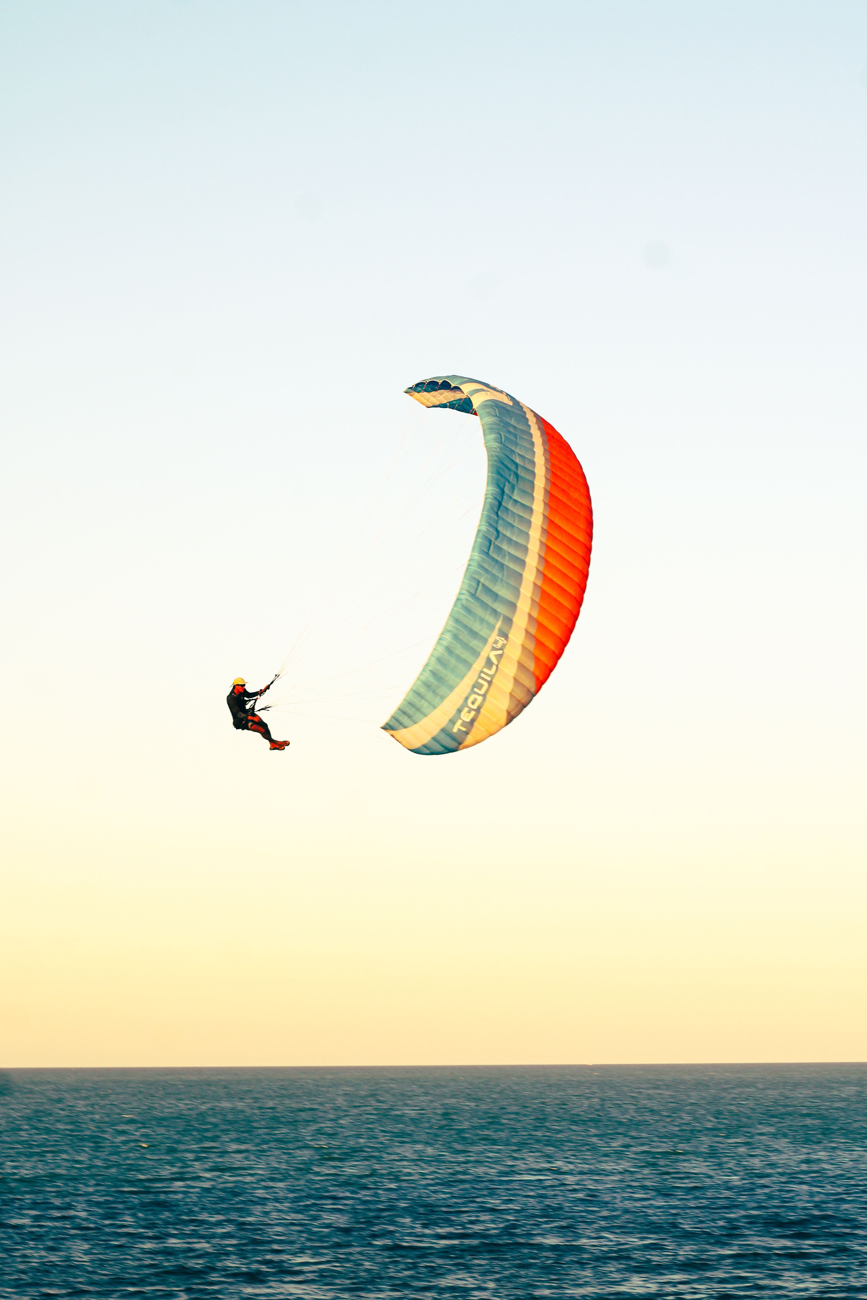 Parapentiste au-dessus de l'océan au coucher du soleil