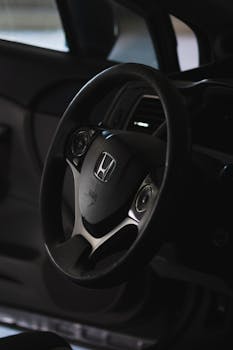 A detailed view of a car's steering wheel in low-light conditions, showcasing design.