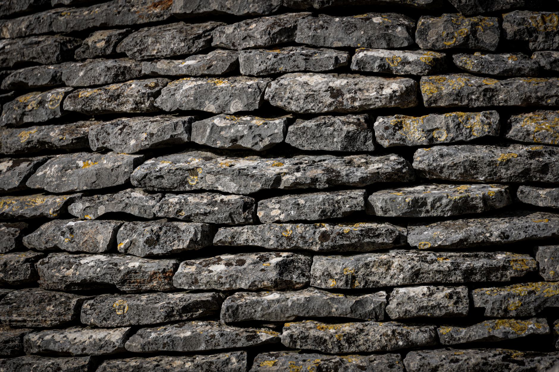 Close-up view of a textured stone wall with stacked rocks.