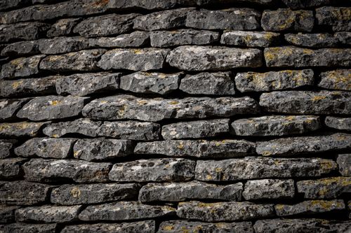 Free Close-up view of a textured stone wall with stacked rocks. Stock Photo