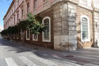 Street view of a charming historic building with trees in Cádiz, Spain.
