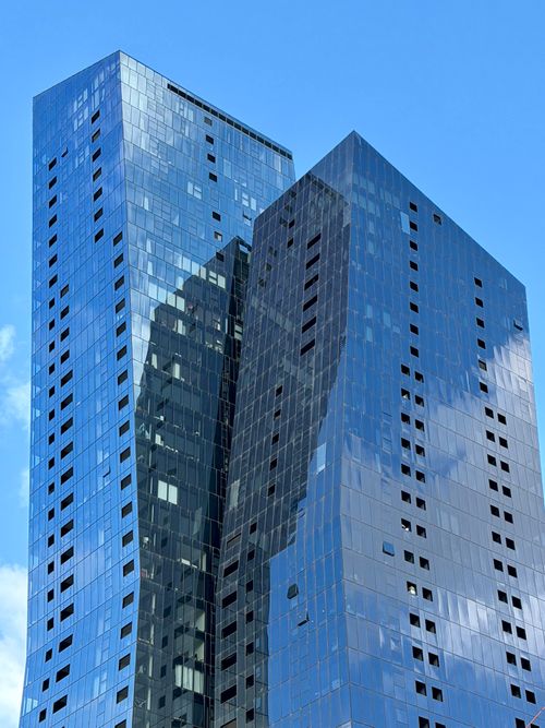 Free A sleek, modern skyscraper with a reflective glass facade in Docklands, Melbourne. Stock Photo