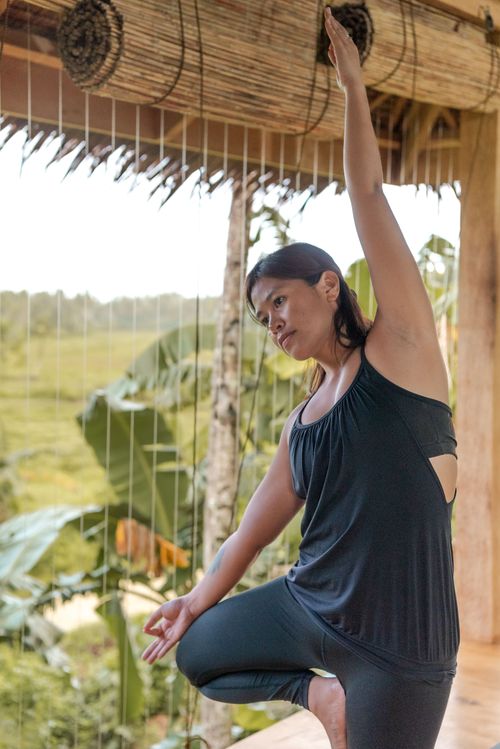 Free Woman practicing yoga pose in a tropical outdoor environment. Stock Photo
