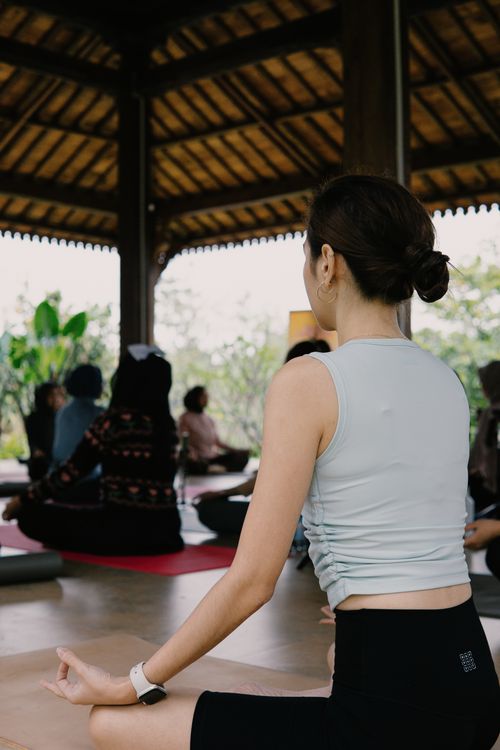 Free Group practicing yoga in a serene Indonesian pavilion, offering relaxation and mindfulness. Stock Photo
