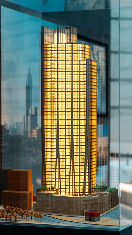 Free Captivating architectural model of a modern skyscraper illuminated and displayed indoors. Stock Photo