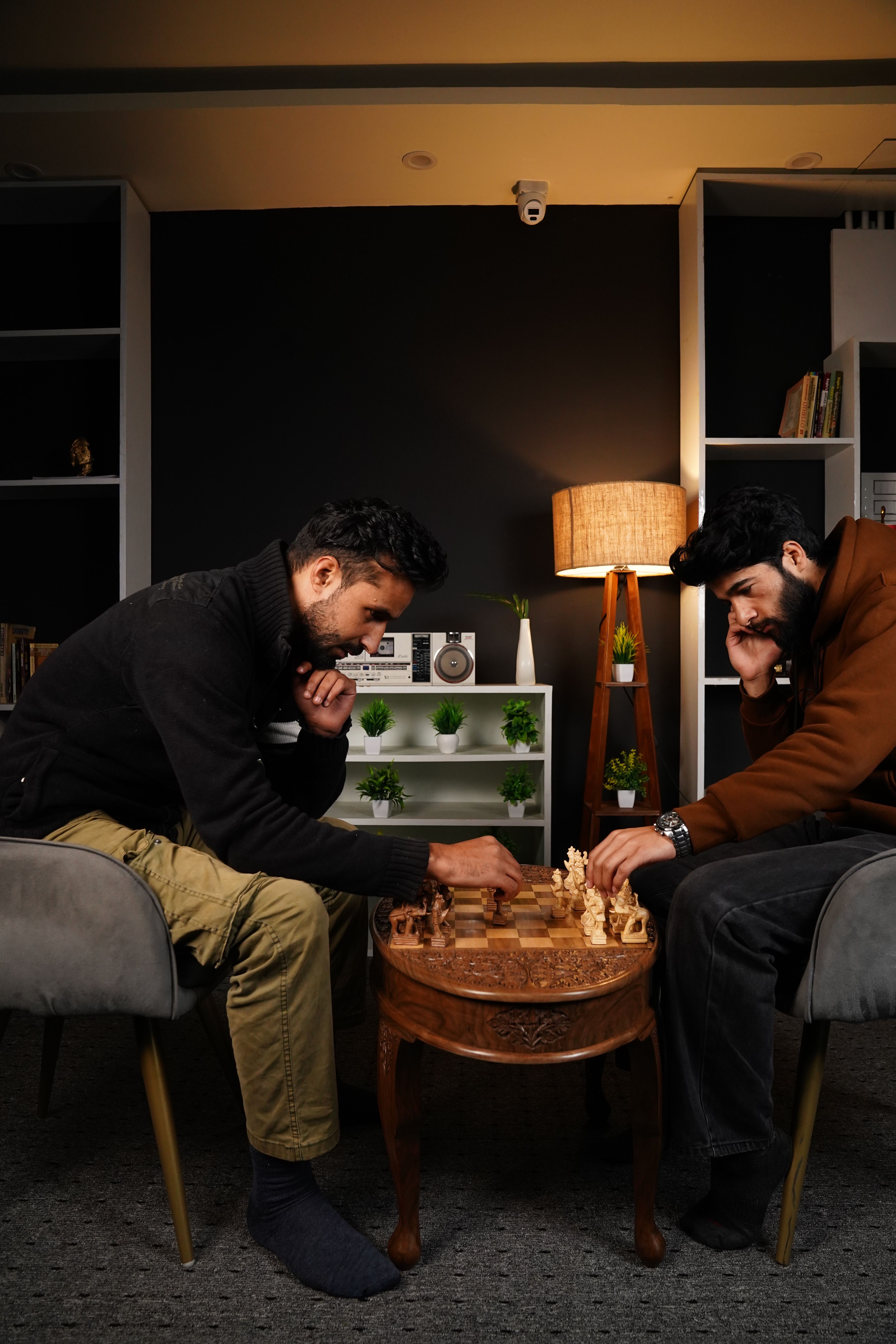Adults focused on a chess game indoors