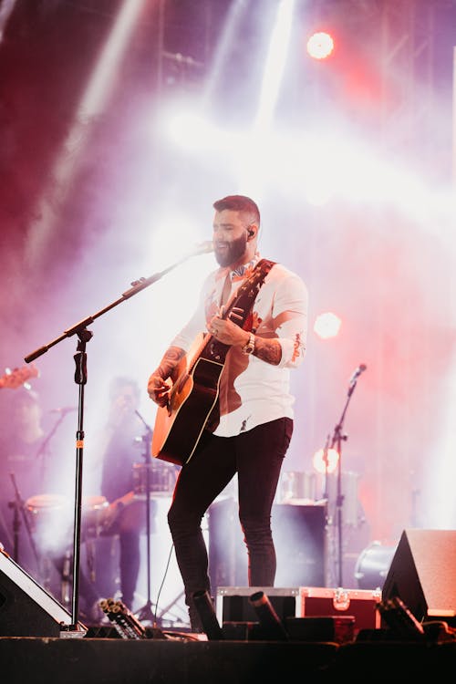 Free Man Playing Guitar on Stage Stock Photo