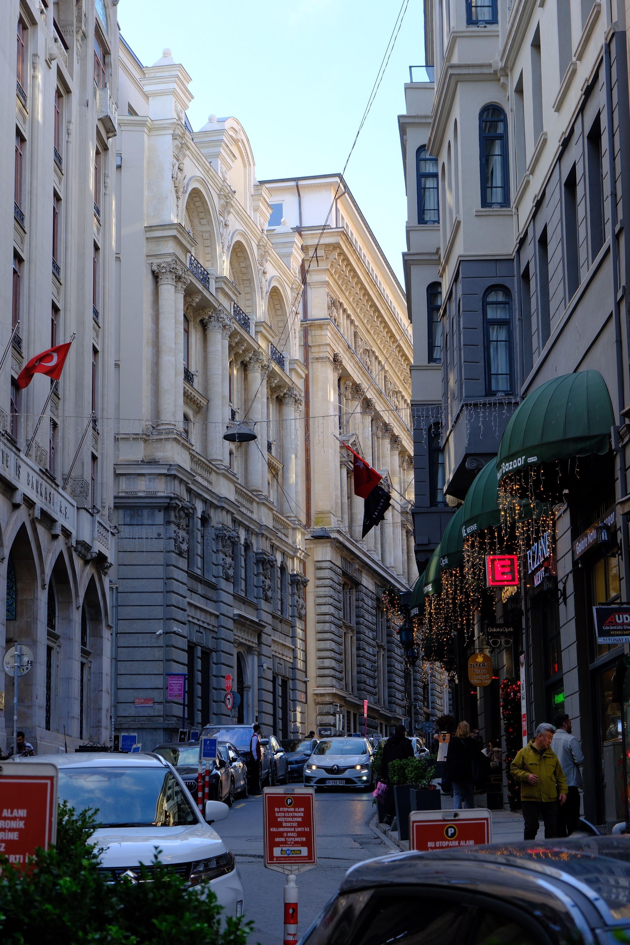 A historic Istanbul street in the early evening, lined with old buildings