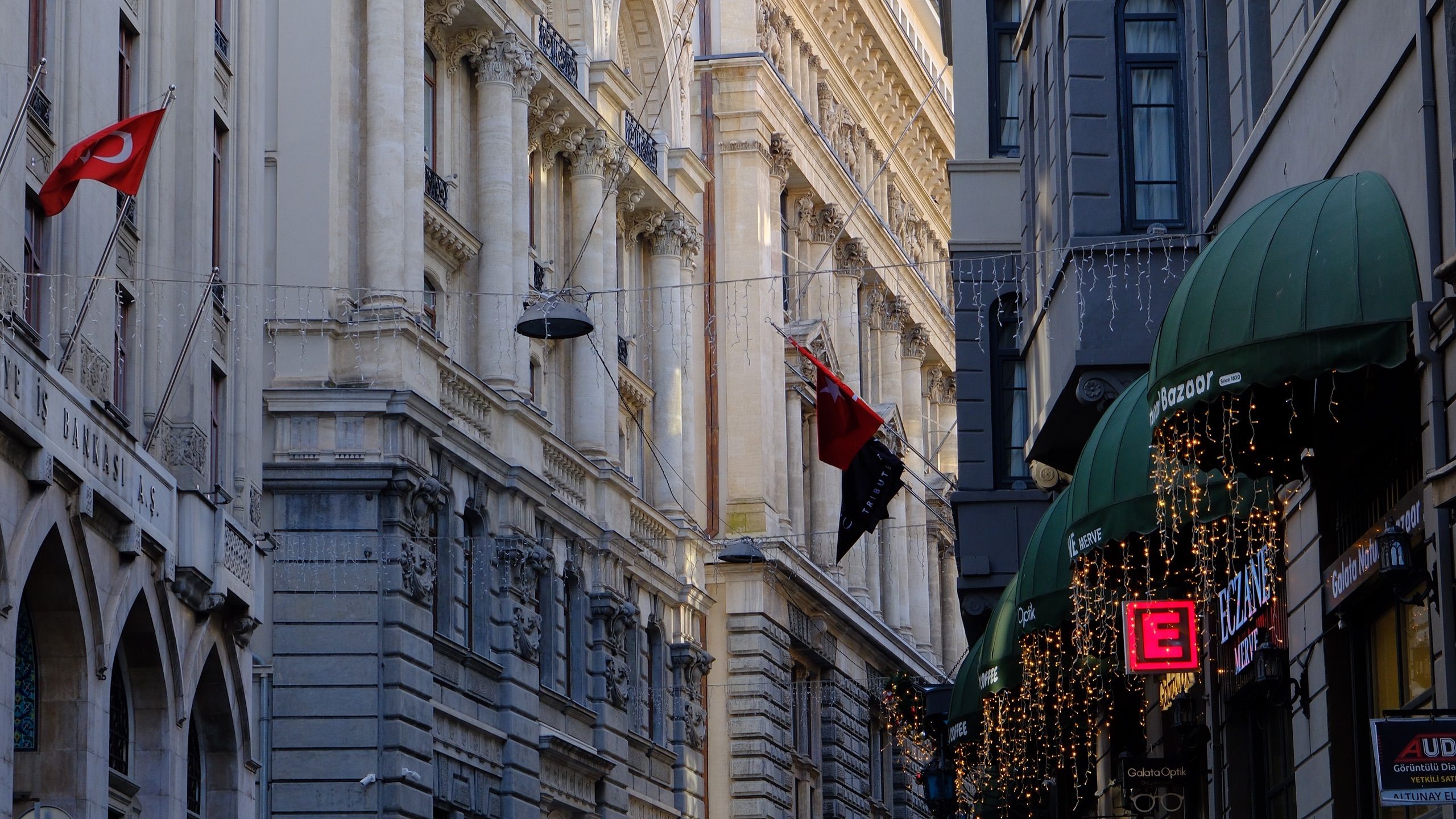 A historic Istanbul street in the early evening, lined with old buildings
