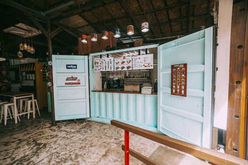 Free Repurposed shipping container as a trendy coffee bar with a rustic interior setting. Stock Photo