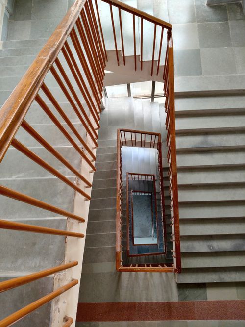 Free View of a spiral staircase with wooden railings from a high angle perspective. Stock Photo