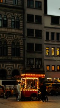 A street vendor illuminated by warm lights in Istanbul's Karakoy district at night.