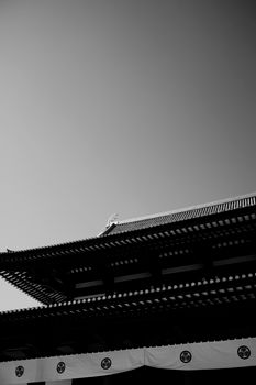 A striking black and white capture of a traditional Japanese temple roof in Tokyo.