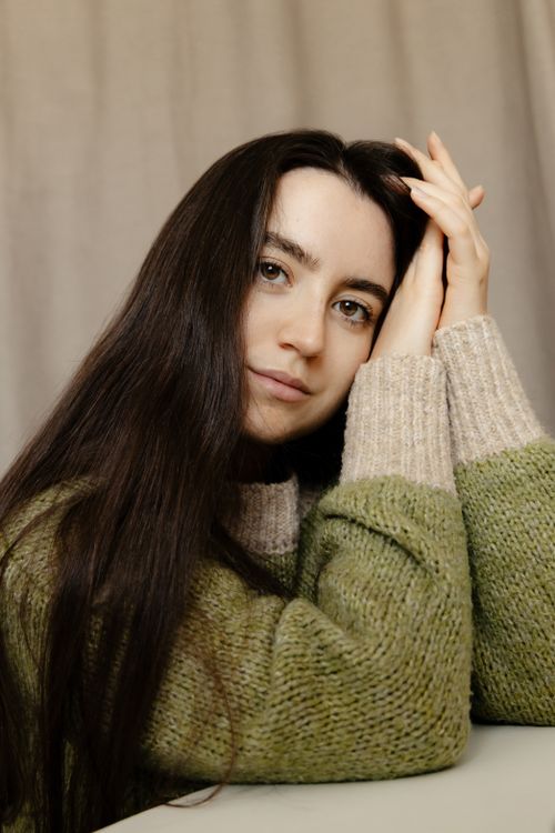 Free A serene portrait capturing a woman in a cozy sweater, embodying tranquility indoors. Stock Photo
