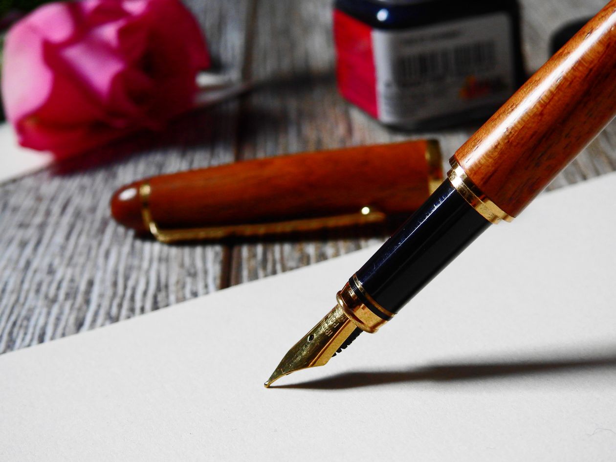 Macro shot of a fountain pen writing on paper with elegant cursive — bottled ink writing test
