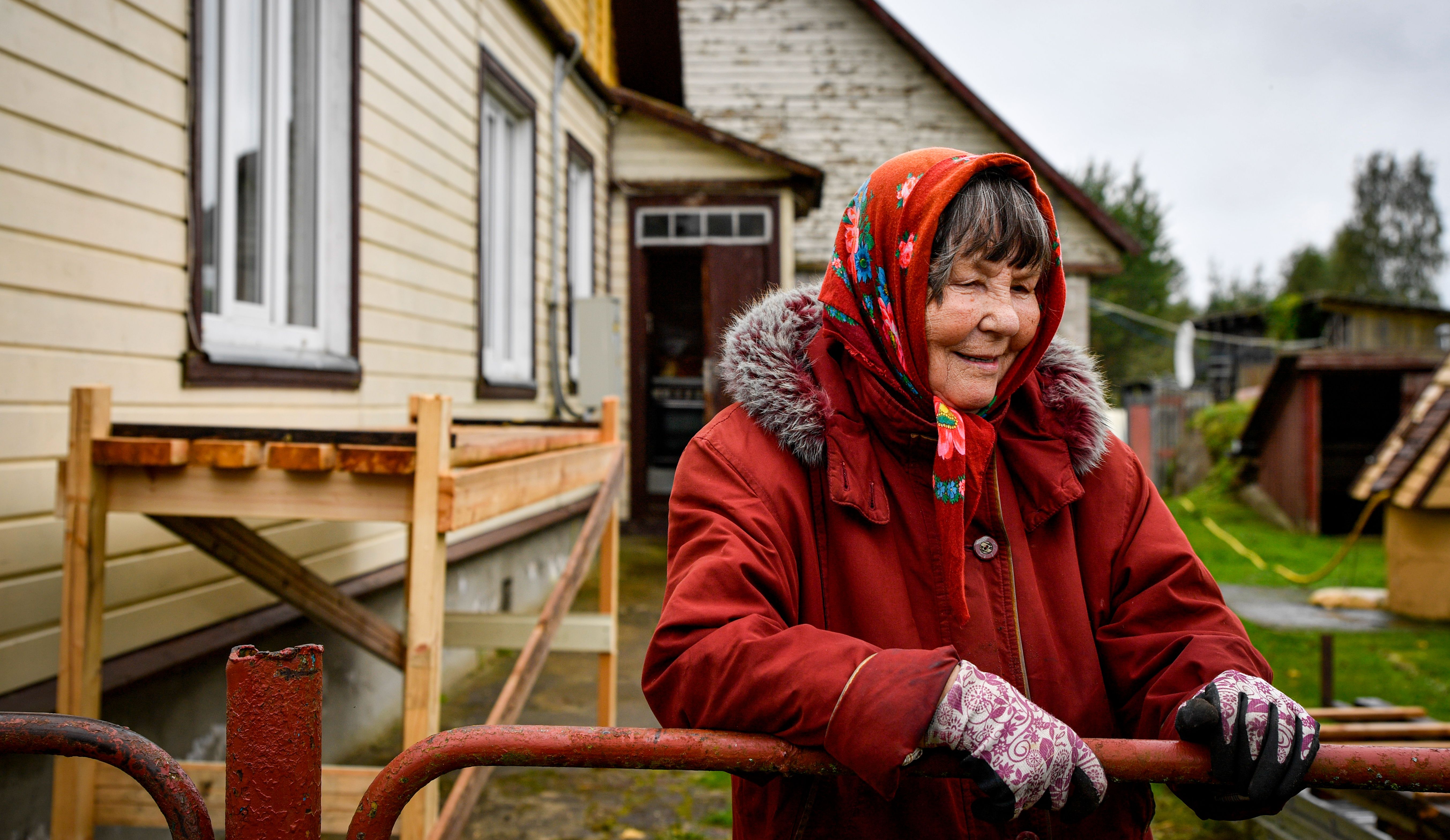 Elderly Woman Smiling by the House in Estonia