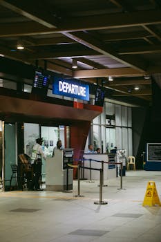 Night view of an airport departure gate with staff and passengers in a modern terminal.
