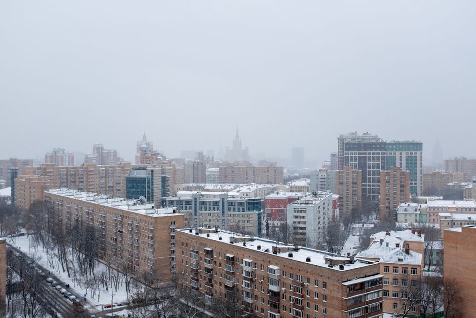 Aerial view of snowy Moscow cityscape featuring residential buildings under a winter sky. Aerial view of snowy Moscow cityscape featuring residential buildings under a winter sky.