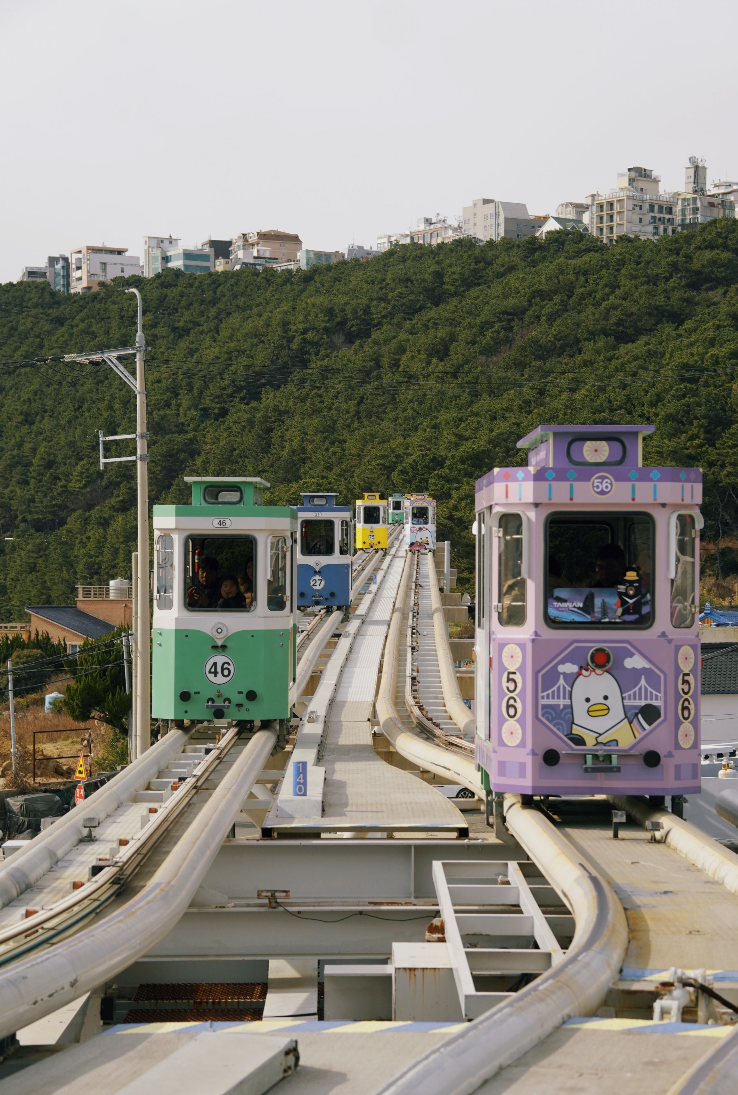 Colorful trams on elevated track in scenic area · Free Stock Photo