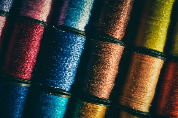 Stacked spools of coloured sewing thread — photo by Chris F on Pexels