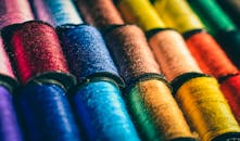 各种颜色缝纫线线轴的特写视图，充满活力