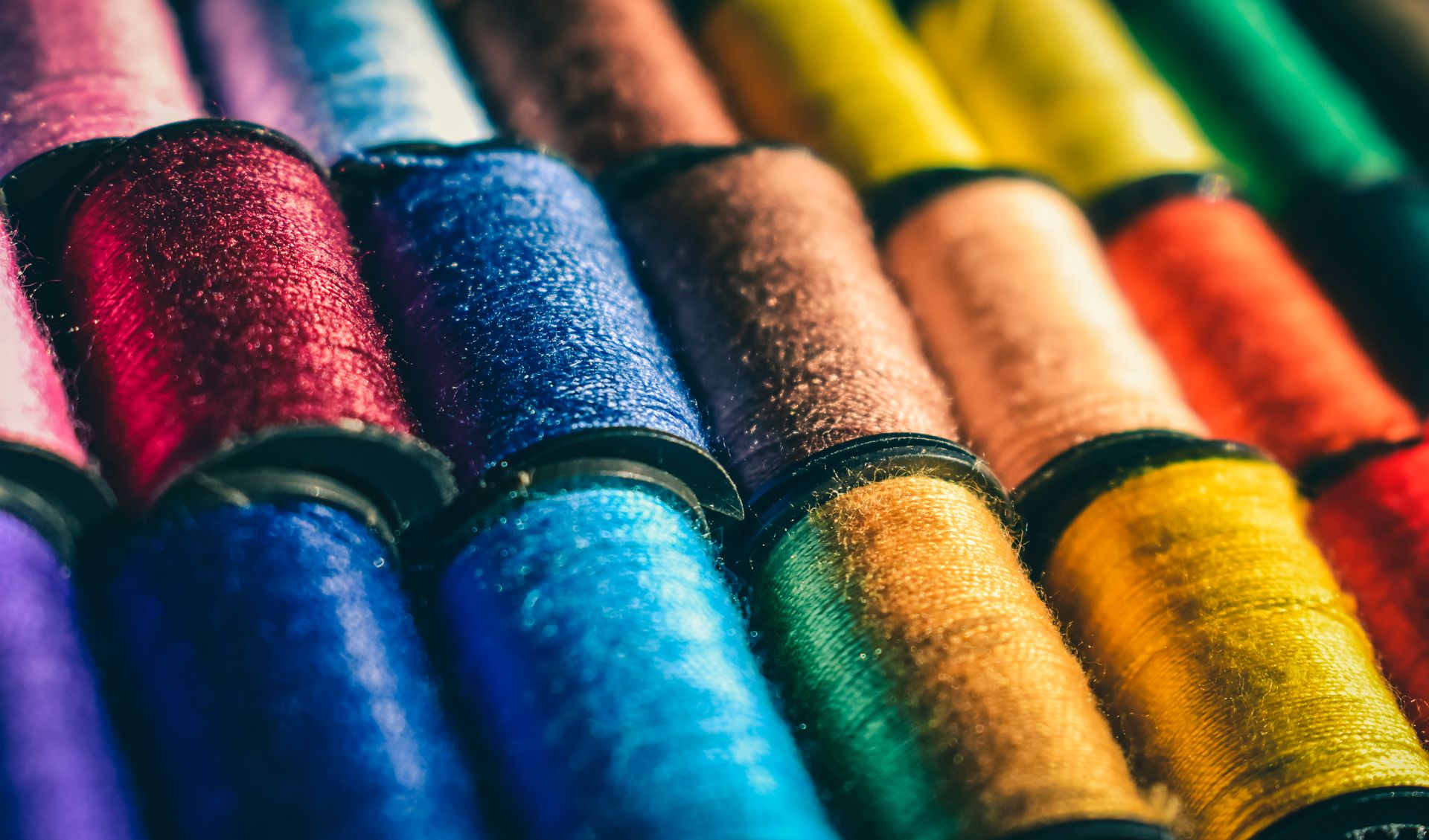 Rows of shimmering embroidery thread spools
