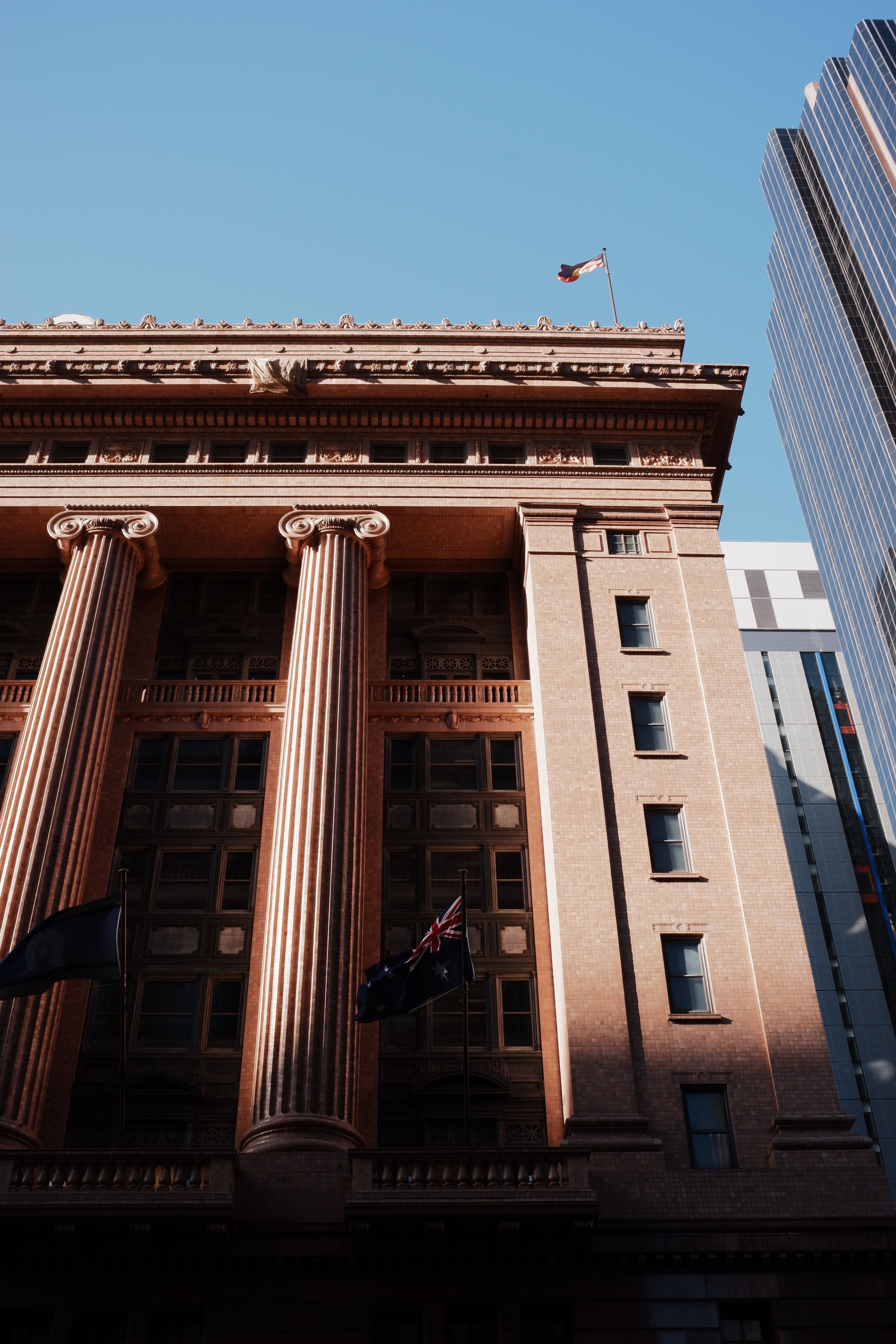 Historic Australian building with flags representing public institutions and finance history