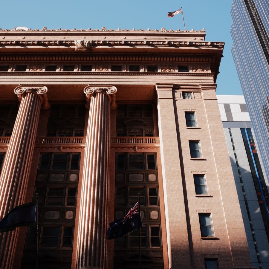 Historic Australian building with flags representing public institutions and finance history