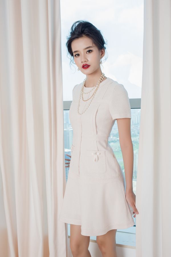 Elegant woman in white dress by window